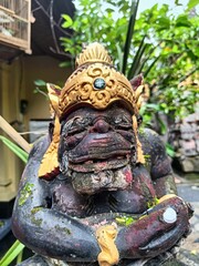 Vertical close-up view of the Balinese statue with golden attributes