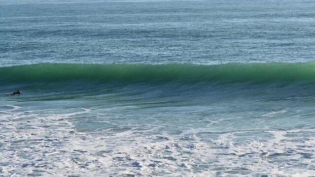 Surfer riding on a smooth nice Atlantic wave in Cadiz, Spain