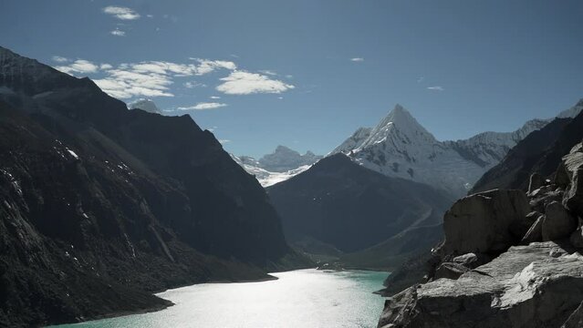 beautiful turquoise water of the lake at laguna paron lagoon in the high andes mountains of the cordillera blanca at huascaran, Peru, with snow covered mountain peaks on a bright sunny day.