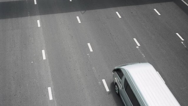 Top view of cars, trucks and bikes driving by the multiline asphalt road of the city. Traffic motion along the interchange expressway
