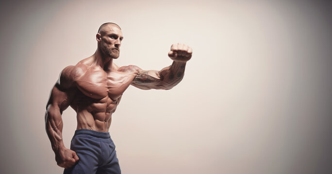 Portrait of extremely muscular man flexing his strong arm