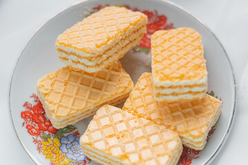 Galletas tipo gaufrette montadas en un plato adornado con flores