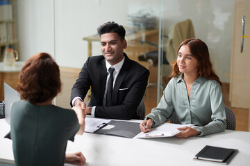 Cheerful team members talking to applicant in job interview