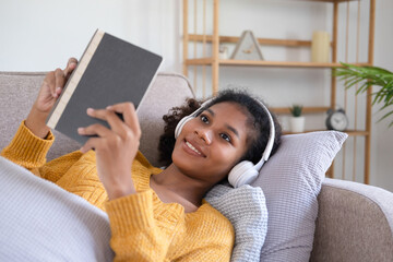 Woman enjoys book and music in modern abode.