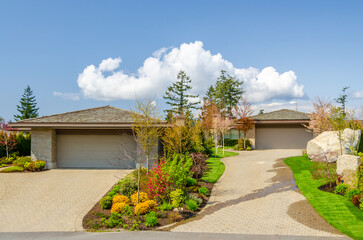 Houses in suburb at Spring in the north America. Garage door of a house with nice landscape.