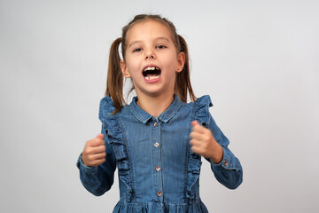 Close-up portrait of screaming little girl in denim dress