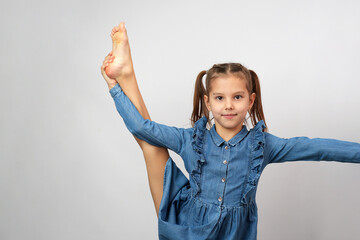 Cute girl holding her leg up with hand, white background