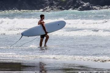 Surfer and board at Manuel Antonio Beach Costa Rica