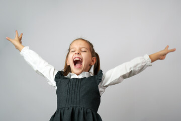 Portrait of cheerful school girl with raised hands