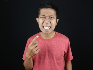 asian man pointing his teeth with surprised and annoyed expression
