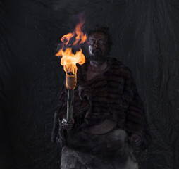 caveman with a torch, black background