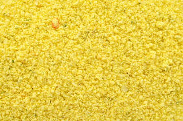 Yellow colored chicken broth powder, background, texture, top view. Fragrant seasoning of chicken broth with vegetables, background, top view. Chicken powder, background, texture, top view.