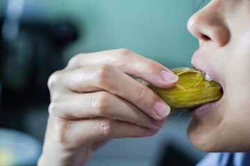 Asian woman is eating Sweet Potatoes, closed up shot.