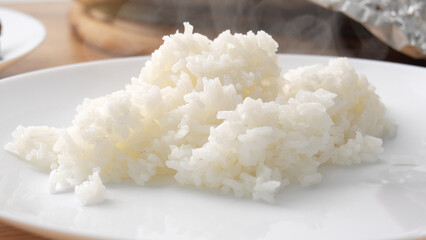 Close-up shot of laying out Steamed White Rice on Plate.