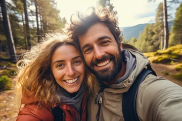 Tafelkleed Cute romantic couple taking a selfie while hiking in a forest. Autumn season. Concept of togetherness in nature and wanderlust © MVProductions