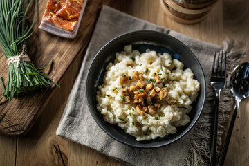 Halusky as traditional Slovak potato gnocchi with sheep cheese bryndza, fried bacon and chives