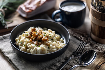 Halusky as traditional Slovak potato gnocchi with sheep cheese bryndza, fried bacon and chives