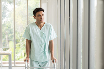 Patient man using walker at hospital ward. Patient man using walker for walk in hospital room