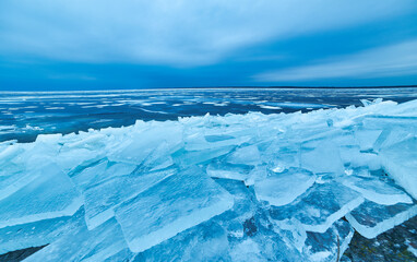 Fototapeta na wymiar Winter's Icy Embrace: Crystal Blue Shores