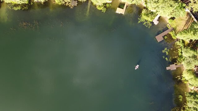 lake coast and a boat seen from above, the boat moore to the pier