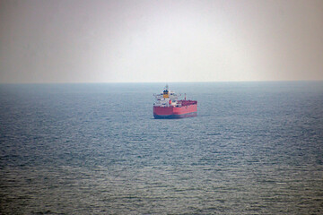 Red and blue ship stands at sea