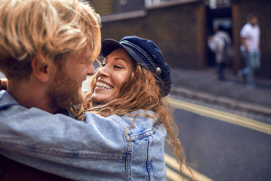 Happy Young Couple Embracing On Date Night In City