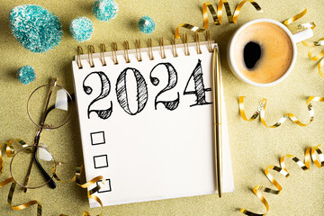 2024 New year resolutions on desk. 2024 goals list with notebook, coffee cup, festive decorations...
