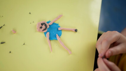 Creative stick figure made with childs modeling clay. kid using imagination to play with hands