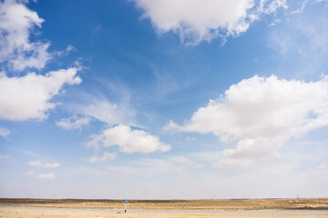 Cloudy blue sky with cumulus clouds in the desert in hot summer