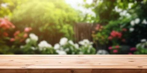 Tuinposter Wooden table in front of blurred garden background, product display montage © MiroArt