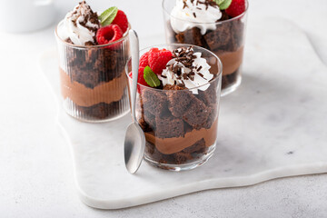 Chocolate mousse and brownie parfait layered in a cup with raspberries