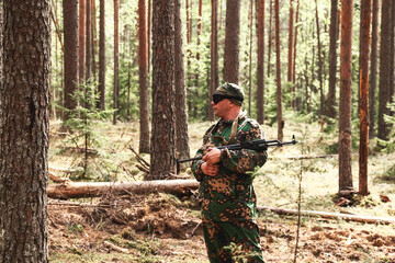 Russian soldier man in military camouflage uniform with weapon on war standing at forest...