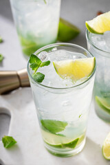 Cold refreshing mojito with lime and mint in tall glasses