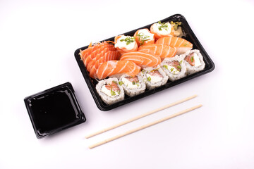 japanese food sushi delivery isolated on background top view angled on white background with chopsticks and soy sauce
