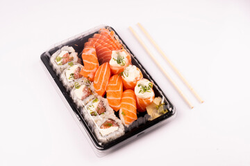 Japanese oriental food tray sushi closed with lid delivery isolated on background top view angled on white background with chopsticks