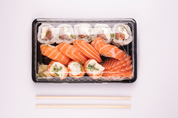 Japanese oriental food tray sushi closed with lid delivery isolated on background top view white background with chopsticks