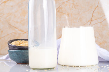 Black and white sesame milk, Alternative vegan non-dairy milk drink on glass and bottles with...