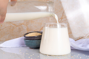 Black and white sesame milk, Alternative vegan non-dairy milk drink on glass and bottles with...