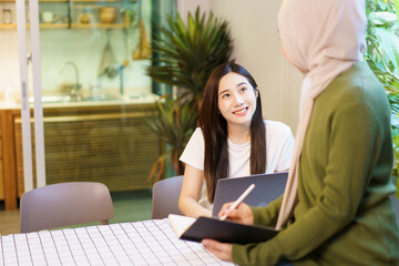 Happy Asian women graduate student discussing and planning a project together.