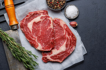 Raw ribeye steaks with savory spices