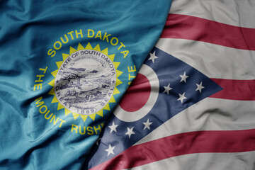 big waving colorful national flag of ohio state and flag of south dakota state . macro