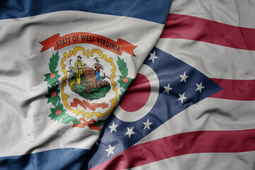big waving colorful national flag of ohio state and flag of west virginia state . macro