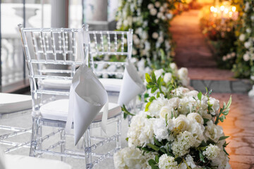 Wedding ceremony. A beautiful and stylish wedding arch, decorated by various fresh white flowers with white chairs, standing. Celebration day.