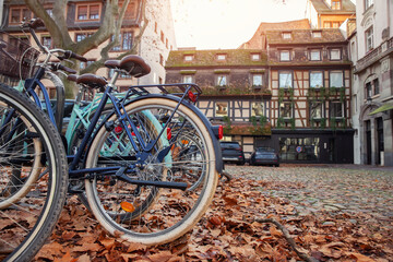 Many vintage modern retro bicycles parked at Alsace Strasbourg city street against medieval old ancient fachwerk building. Sustainable eco transport. Bike riding lifestyle. Cycle sharing rental