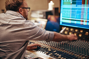 Music producer working with audio equipment in a recording studio
