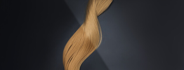 Blond shiny hair wave, on black background. Hairdresser salon equipment concept, hairdressing set....