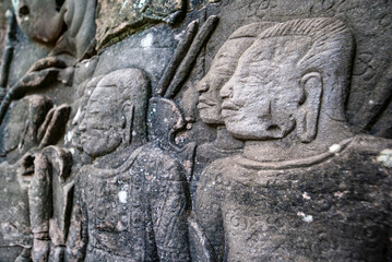 Fototapeta na wymiar Male warriors with large earlobes carving on the facade of Angkor Thom Bayon, Angkor. Cambodia, Asia