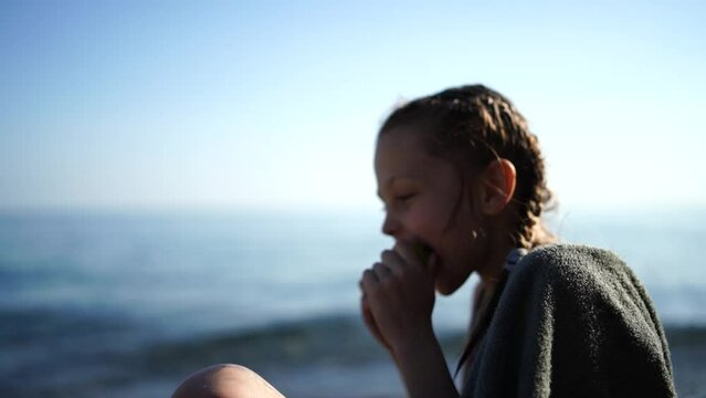 Child eating apple beach. Having snack on the beach. Girl at the resort.