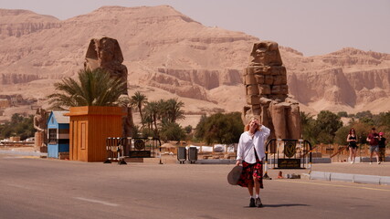 Woman tourist in Colossi of Memnon in Luxor Egypt