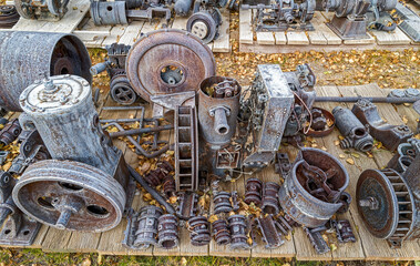 Antique metal engine parts on a pallet outside